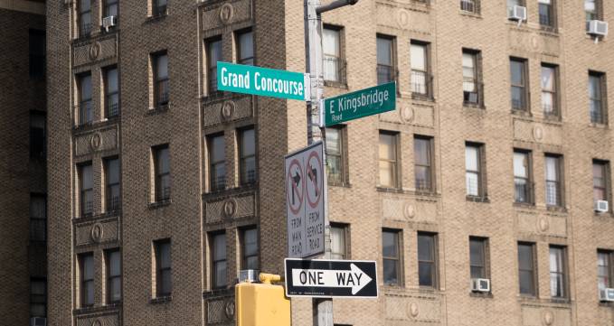 street signs at a corner in front of a building